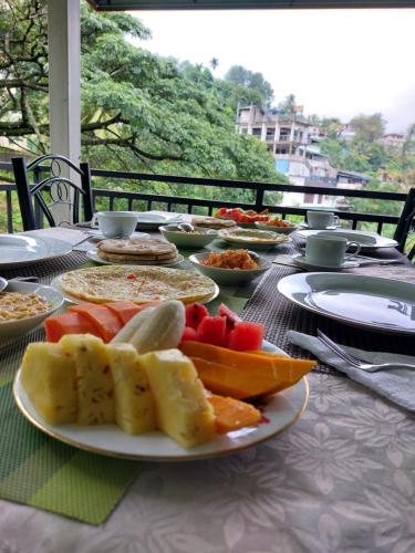 a table with a plate of food on it at Jaye's Homestay in Kandy