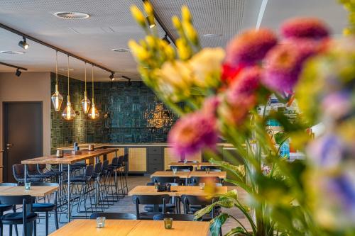 a restaurant with tables and chairs and flowers at PLAZA INN Ulm in Ulm