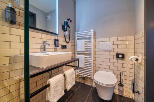 La salle de bains est pourvue d'un lavabo blanc et de toilettes. dans l'établissement NYCE Hotel Ulm, à Ulm
