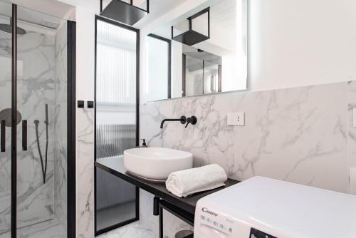 ein weißes Bad mit einem Waschbecken und einer Dusche in der Unterkunft Dream Loft in Turin