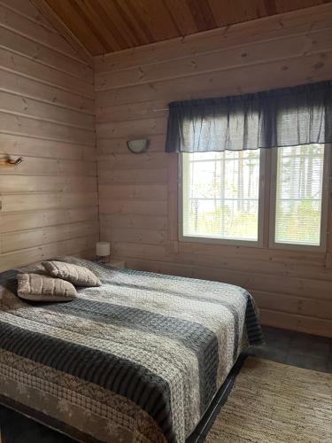 1 dormitorio con 1 cama en una cabaña de madera en Holiday Home Amero purnu 4 en Kolinkylä