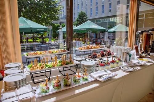 a buffet of food on a table in front of a window at Hotel Gromada Warszawa Centrum in Warsaw