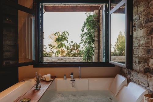 ein Bad mit einer Badewanne und einem großen Fenster in der Unterkunft Lefkara Luxury Suites in Pano Lefkara