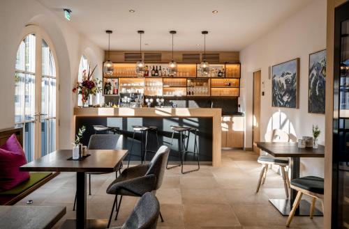a restaurant with tables and chairs and a bar at NEUWIRT - Boutiquehotel & Wirtshaus in Bad Vigaun