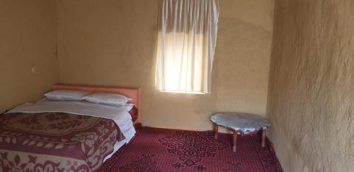 ein kleines Schlafzimmer mit einem Bett und einem Fenster in der Unterkunft Auberge Camping La Khaima in Merzouga