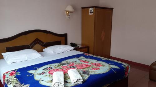 a bedroom with a bed with two towels on it at Hotel Parewisata in Parepare