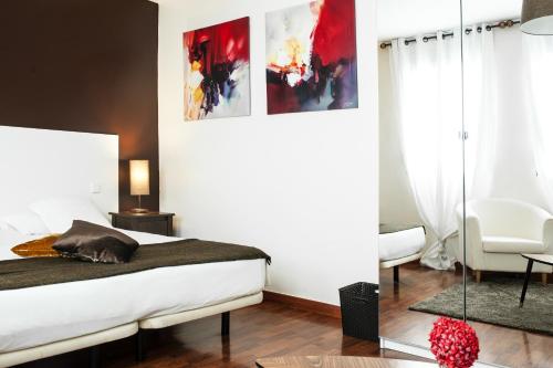 a bedroom with a bed and a chair in it at THC Gran Via Hostel in Madrid