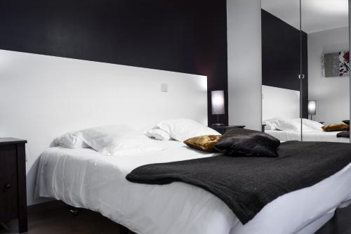 a bedroom with a large white bed with a black blanket at THC Gran Via Hostel in Madrid