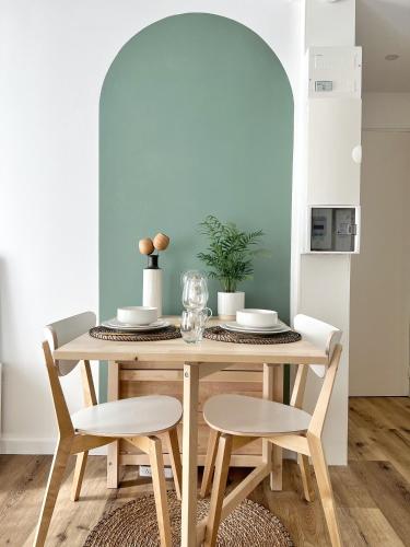 - une table à manger avec deux chaises, une table et une table dans l'établissement Le Cocon - Coeur de ville, à La Rochelle