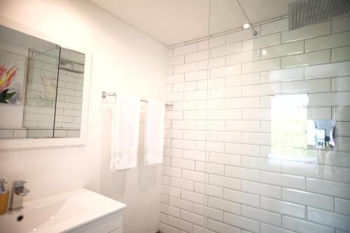 uma casa de banho branca com um lavatório e um espelho em Rockwell 304 em Cidade do Cabo