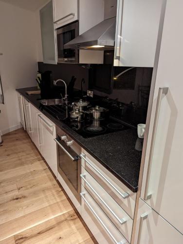 a kitchen with a stove and a counter top at Modern 1 bedroom City- Apartment Central stylish living in Croydon