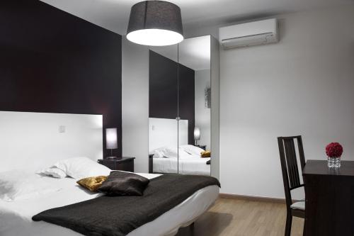 a bedroom with a bed and a large mirror at THC Gran Via Hostel in Madrid