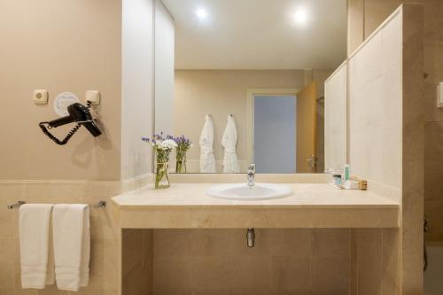 een badkamer met een wastafel en een spiegel bij Ilunion Fuengirola in Fuengirola