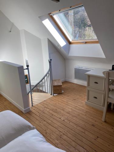 an attic bedroom with a skylight and a bed and a desk at Maîson Vigneronne in Nazelles