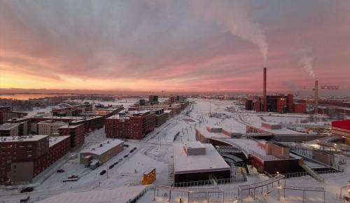 a city covered in snow with a sunset in the background at Fabulous Morden Apartment in Helsinki in Helsinki