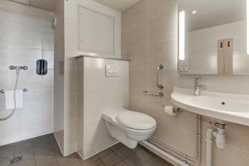 uma casa de banho branca com um WC e um lavatório em B&B HOTEL Marseille Prado Vélodrome em Marselha