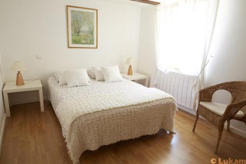 1 dormitorio blanco con 1 cama y 1 silla en Gîte Le Vendangeur, en Donnenheim