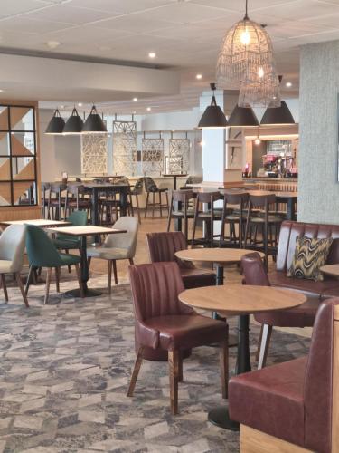 a restaurant with tables and chairs and a bar at Sedgebrook Hall in Northampton