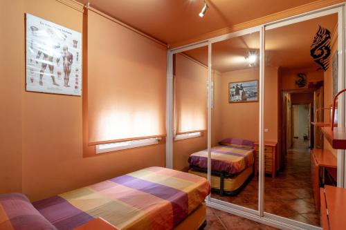 een kamer met 2 bedden en een spiegel bij Acogedor apartamento centro ciudad, 1m playa, Terraza in Fuengirola