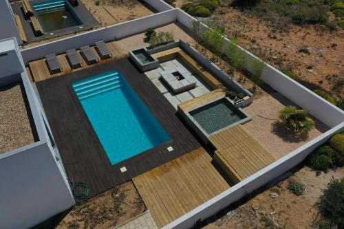 einen Blick über den Pool auf einer Holzterrasse in der Unterkunft Cairnvillas: Villa Terra C39 - Luxury Villa with Private Swimming Pool near Beach in Aljezur