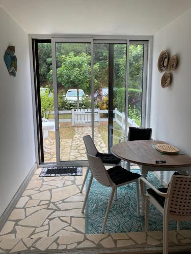 une salle à manger avec une table et des chaises et une fenêtre dans l'établissement La Pinède de Saint Georges, à Saint-Georges-de-Didonne