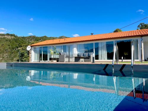 a house with a swimming pool in front of it at Casas Capela by O'Porto Seven in Ferral