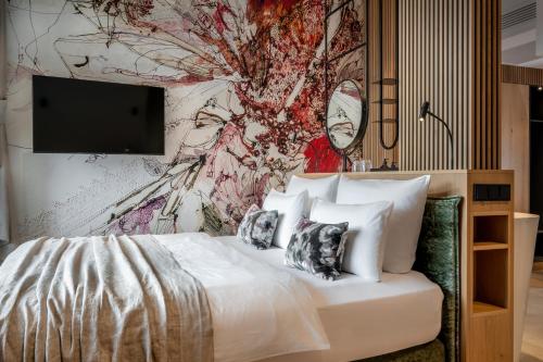 sypialnia z łóżkiem z malowidłem ściennym w obiekcie NEUWIRT - Boutiquehotel & Wirtshaus w mieście Bad Vigaun