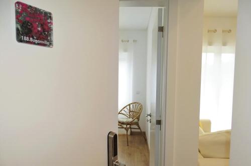een hal die leidt naar een woonkamer met een stoel bij 188 Apartments - Buganvília - pool and balcony in Cascais