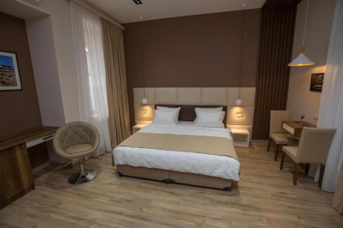 a bedroom with a bed and a desk and a chair at History Hotel Tbilisi in Tbilisi City