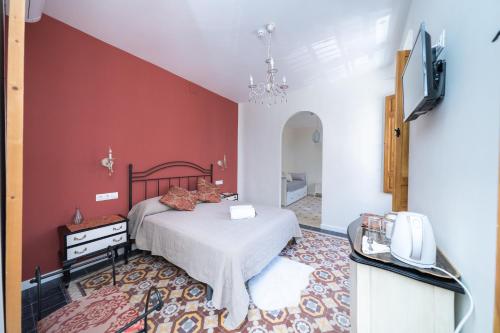 a bedroom with a bed and a red wall at Villa Moana in Iznájar