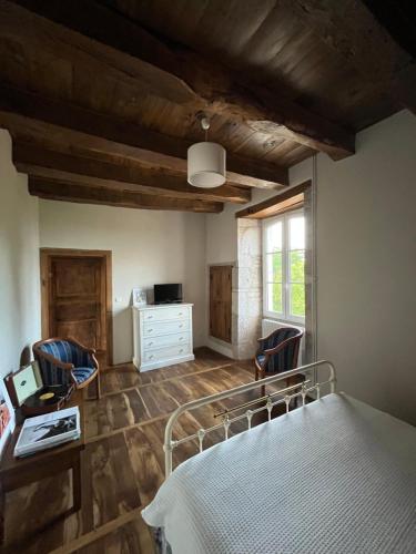 1 Schlafzimmer mit einem Bett und 2 Stühlen in der Unterkunft Le Mas de Coursac in Quissac
