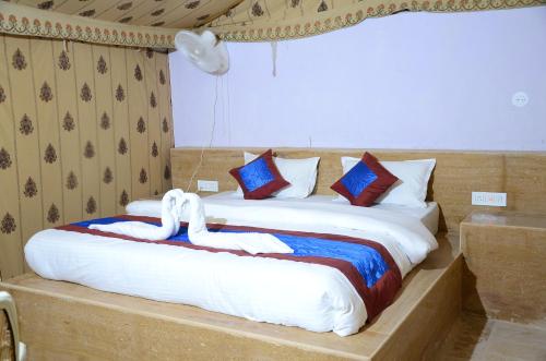 a bed with two swans on it in a room at Marina Dessert Camp in Sām