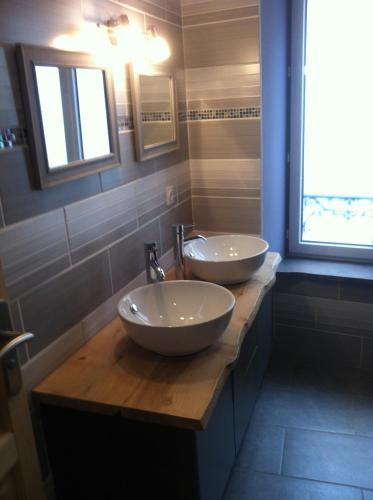 deux lavabos sur un comptoir en bois dans une salle de bain dans l'établissement Villa Boston, à La Bourboule