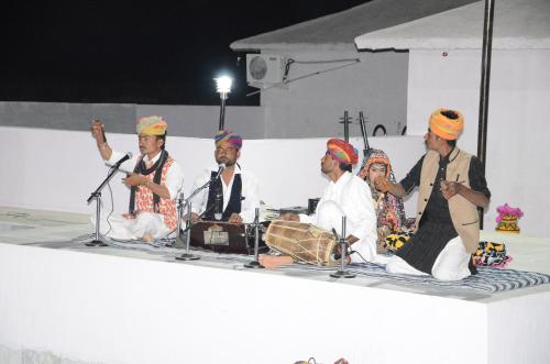 a group of people sitting on a stage at Marina Dessert Camp in Sām