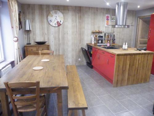 a kitchen with a large wooden table and a counter at Villa Boston in La Bourboule