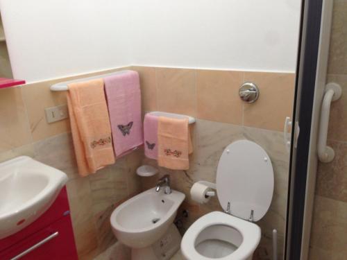 een badkamer met een toilet, een wastafel en handdoeken bij CASA CON VERANDE SUL MARE a 2 MINUTI A PIEDI DALLA SPIAGGIA in Custonaci