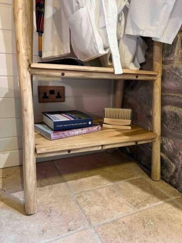 a wooden shelf with some books on it at Charming stone Bothy at Loch Lomond in Luss