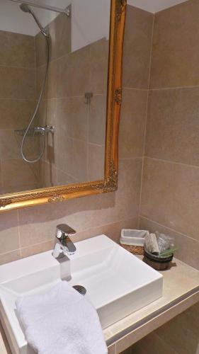 a bathroom with a white sink and a mirror at Hotel Relais Du Postillon in Antibes