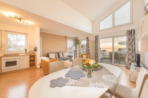 a living room with a table with flowers on it at Penthouse STRANDBURG mit Meerblick in Sassnitz