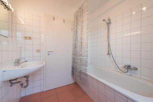 y baño con bañera, lavamanos y bañera. en Penthouse STRANDBURG mit Meerblick en Sassnitz