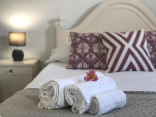a pile of towels on a bed in a bedroom at Casa do Largo in Lagoa