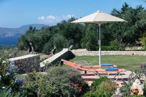 a couple of chairs and an umbrella and an umbrella at Villa Luni in  Episkopi (Chania)