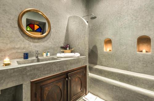 W łazience znajduje się umywalka i lustro. w obiekcie Riad Boustane w Marakeszu