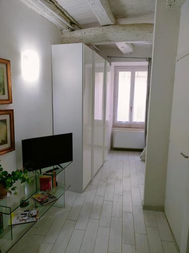 a living room with a flat screen tv on a white wall at Il CORTILETTO Casa Vacanza Trevi in Trevi