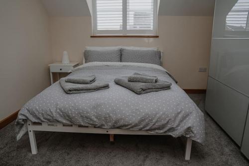 a bed with pillows on it in a bedroom at Lovely new 1 bedroom loft apartment with on drive parking in Trowbridge