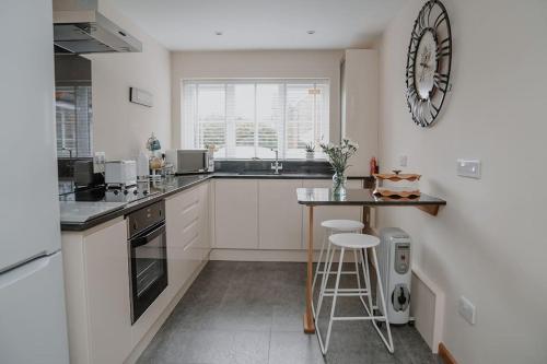a kitchen with a counter and a clock on the wall at Lovely new 1 bedroom loft apartment with on drive parking in Trowbridge