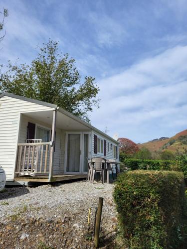 Cette petite maison dispose d'une terrasse couverte et d'une table. dans l'établissement Camping Ixtila mobilhome, à Larrau