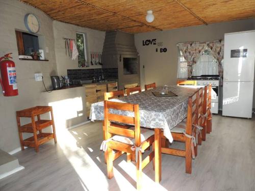 a kitchen with a table with chairs and a refrigerator at Cango Retreat Breathe in Oudtshoorn