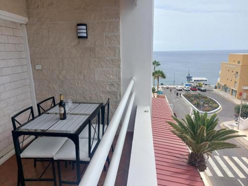 a balcony with a table and a view of the ocean at gomera view experience in Callao Salvaje