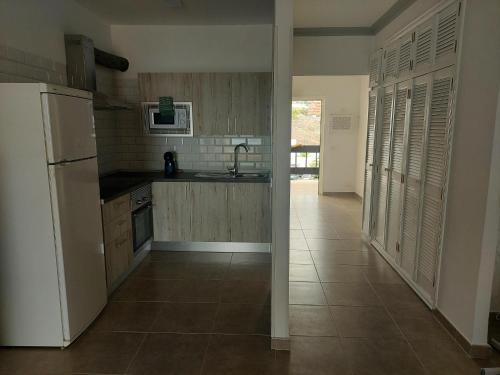 a kitchen with a white refrigerator and a tile floor at gomera view experience in Callao Salvaje